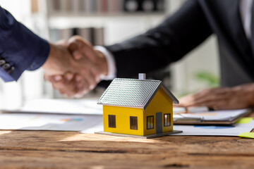 Real estate agent shakes hands with customer after finished contract after about home insurance and...
