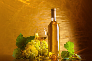 Fototapeta premium Wine. Bottle and a glass of white wine with ripe grapes still life. White wine.