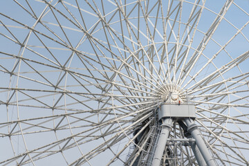 A giant ferris wheel pillar structure with blye sky in daytime as background. Close-up and...