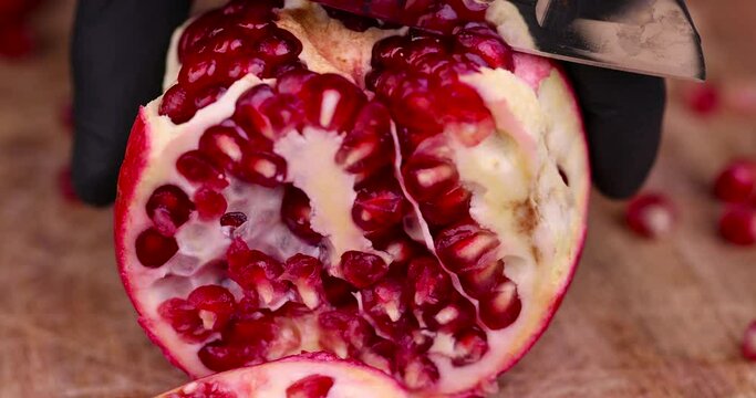 red ripe pomegranate with red grains, open pomegranate fruit on the table