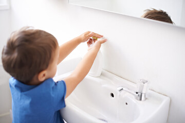 Child, boy and liquid soap for washing hands in bathroom, hygiene and prevention of germs or...