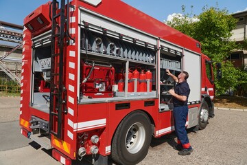 Fototapeta na wymiar A dedicated firefighter preparing a modern firetruck for deployment to hazardous fire-stricken areas, demonstrating readiness and commitment to emergency response