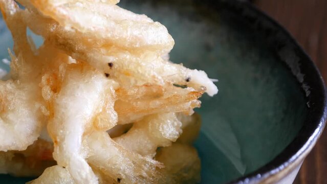 富山県の特産物の白えび。天ぷらにした白エビをお皿に乗せていくクローズアップ動画。下から上へ。