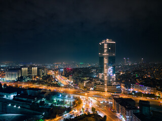 Fototapeta na wymiar Istanbul's glass and concrete skyscrapers, home to offices, hotels, and residential complexes at night. Aerial drone view