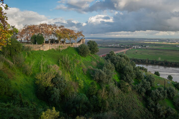 Hill with vegetation and green grass with castle wall at the top and overlooking the Tejo river, Santarém PORTUGAL