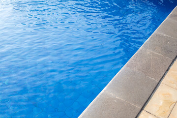Clear blue water in the pool in the sunshine.