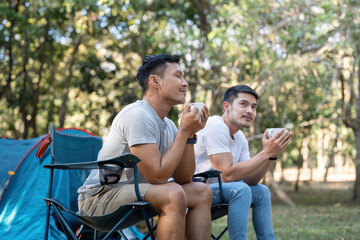 Happy Asian male gay couple on camping together in a forest. romantic vocation trip. lgbt concept