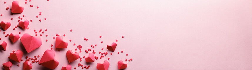 Paper origami hearts on pink background