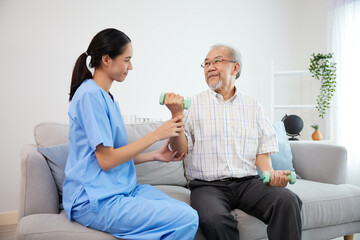 nurse or caregiver helping elderly patient to physiotherapist and exercise for rehabilitation at...