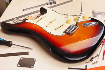 Body of electric guitar at workplace of guitar technician. - obrazy, fototapety, plakaty