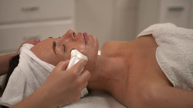 woman receiving massage. microcurrent facial massager. massage with a special device. Slow motion video. High quality video in 4K format.