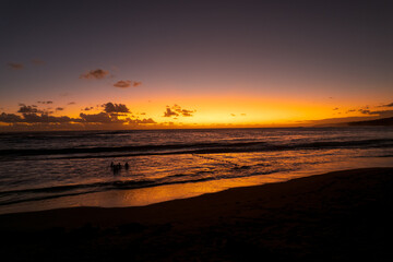 Sunset on the beach of L'Étang-Salé, one of the rare beaches of the island made of volcanic sand,...