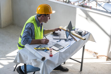 Serious Caucasian builder using tablet in workplace