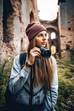 shot of a young woman taking pictures while exploring an ancient ruin