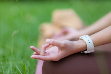Woman practicing yoga lesson breathing meditating at outdoor park