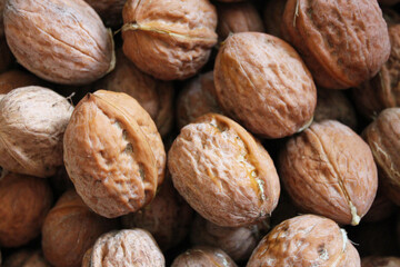 Row brown walnuts in nutshells, texture background