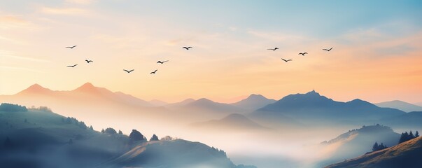 view of the mountains in the morning with light mist and birds flying