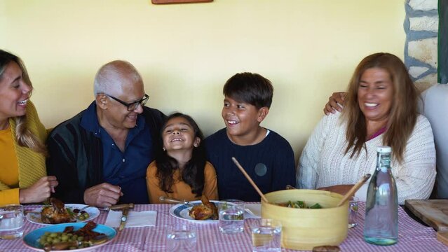 Happy multi generational latin family having fun together after lunch at house terrace