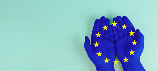 Hand with EU flag, european union, cooperation between the countries of Europe, Association of states - obrazy, fototapety, plakaty
