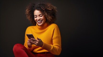 Young woman smiles joyfully while holding her smartphone against a colored background.