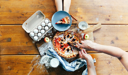 Crop person cutting pie on table