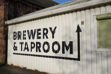 Sign for Brewery and taproom on side of building. beer and ale this way