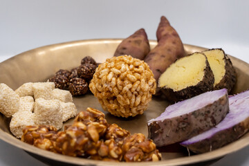 Maghe Sankranti Makar Festival Celebration Food Plate of Muri Ladoo, Sesame Ladoo, Yam, Sweet Potato, Jaggery, Peanuts Ladoo Ghee in India and Nepal
