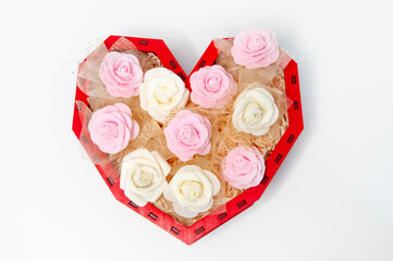White and pink roses in heart shaped box on white background