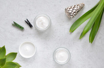 Fototapeta na wymiar jars with face cream on a gray table flat lay