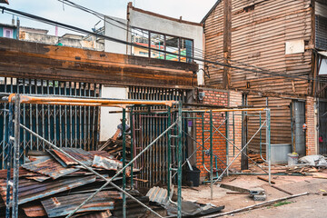 Naklejka premium Deconstruction of old wooden house. Demolish old wooden houses in Asian styles shophouses to improve area. The abandoned and dilapidated Asian old style shophouses. Demolition home. Selective focus.