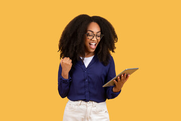 Excited young black woman with tablet celebrating success