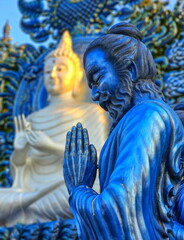 Praying monk statue at Wat Rong Suea Ten Blue temple, Chiang Rai, Thailand
