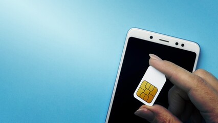 top view hand holding sim card with smartphone copy space