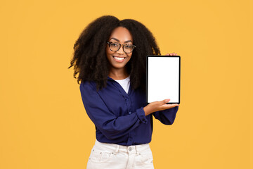 Happy black young student lady showing tablet with blank screen, recommending educational courses...