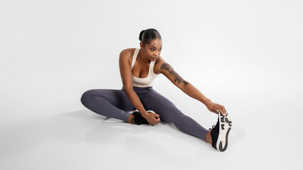 Fototapeta na wymiar athletic black woman in sportswear has workout in white studio