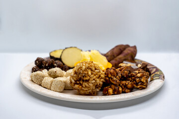 Maghe Sankranti Makar Festival Celebration Food Plate of Muri Ladoo, Sesame Ladoo, Yam, Sweet Potato, Jaggery, Peanuts Ladoo Ghee in India and Nepal