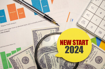 NEW START 2024 on yellow sticker with pen and calculator