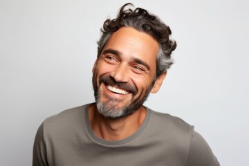 Portrait of a happy man smiling and looking at the camera on a gray background