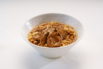 Signature Satay Beef Instant Noodles served in bowl isolated on wooden table side view of hong kong fast food