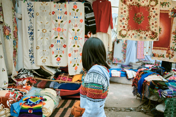 Obraz na płótnie Canvas Woman looking at traditional market stall in Otavalo, Ecuador