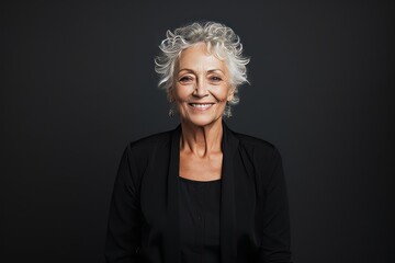 Portrait of a happy senior woman smiling at the camera isolated on black background