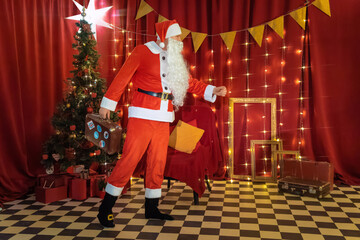 Santa Claus standing in a room with a Christmas tree and presents