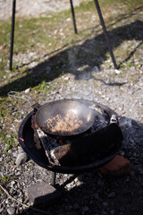Campfire cooking of food in the nature while camping in summer