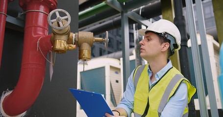 A engineer under checking inspects the industry factory pressure water pump valves equipment in a...