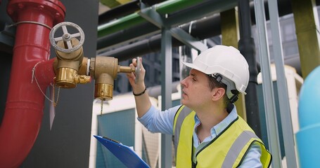 A engineer under checking inspects the industry factory pressure water pump valves equipment in a...