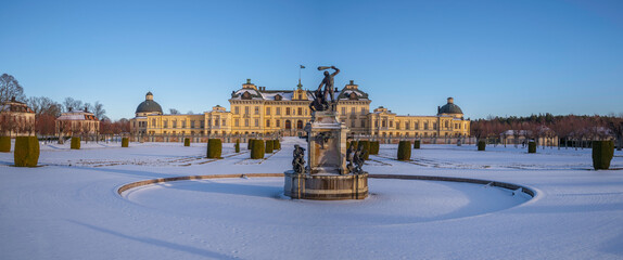 Panorama, snowy view over a winter garden and a castle in a park, on the Drottningholm island in...