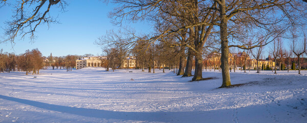 Panorama, snowy view over a winter garden and a castle in a park, on the Drottningholm island in Stockholm, Sweden
