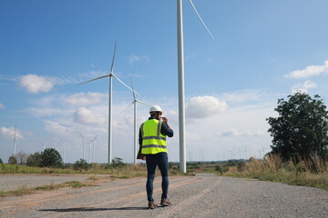 Obraz premium Blue collar worker at electricity site. Windmill farm