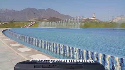 A mesmerizing hillside adorned with cascading greenery, where a graceful water fountain takes center stage. Crystal-clear streams from the fountain flow gently, mirroring the vibrant surroundings.