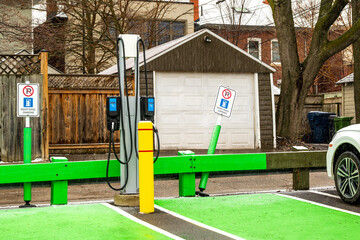 Fototapeta na wymiar green infrastructure: electric vehicle charging stations in public parking lot shot in beaches nieghbourhood toronto